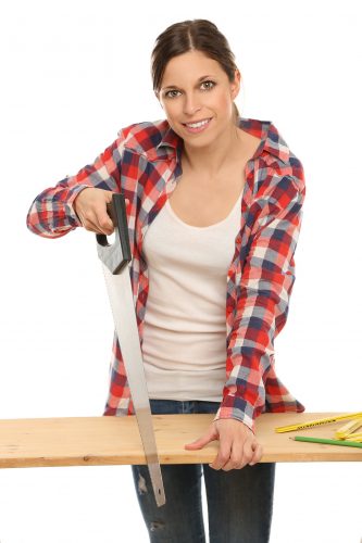 Junge Frau sägt ein Holzbrett